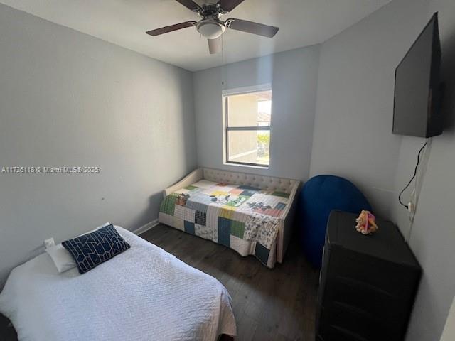 bedroom featuring ceiling fan and dark wood-type flooring