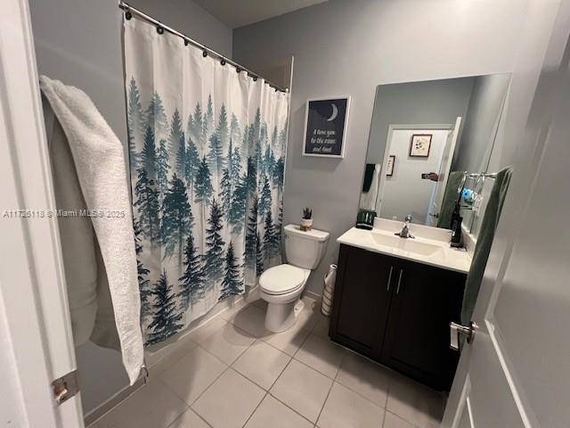 bathroom with vanity, tile patterned flooring, toilet, and walk in shower