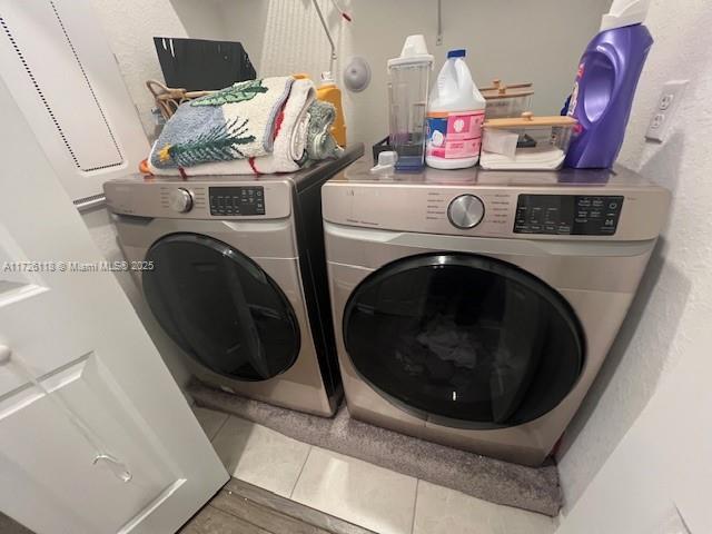 clothes washing area with tile patterned flooring and separate washer and dryer