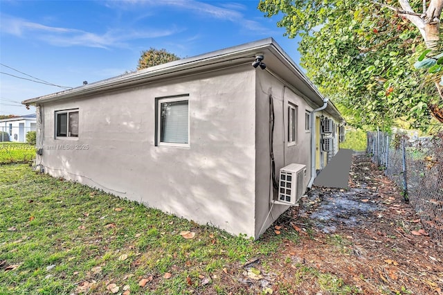 view of side of property featuring ac unit and a yard