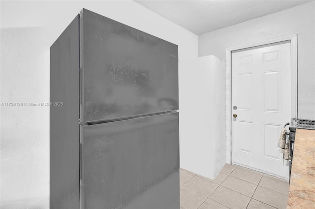 interior space featuring black refrigerator and light tile patterned floors