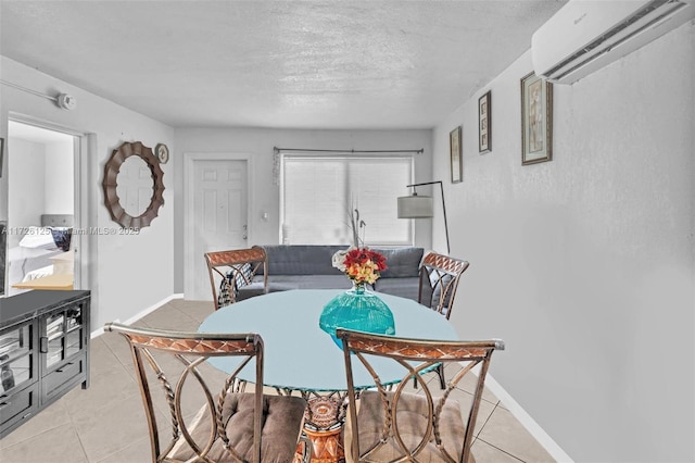 dining area with a textured ceiling, light tile patterned floors, and an AC wall unit