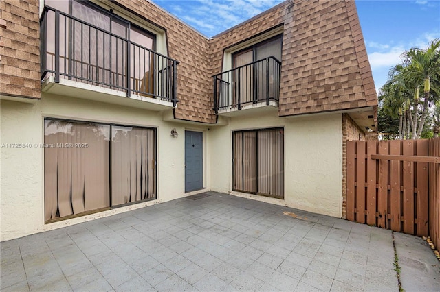 rear view of property with a patio area and a balcony