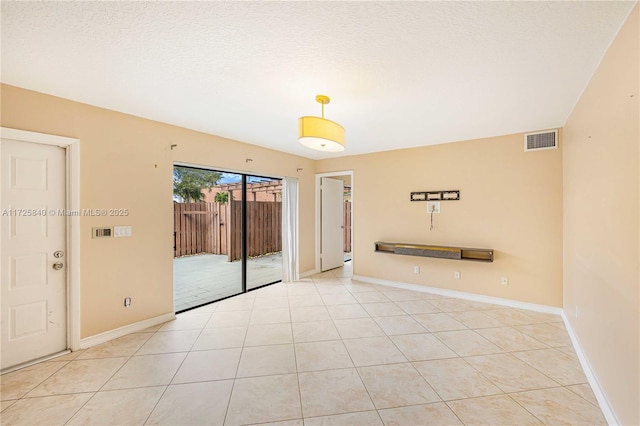 tiled spare room with a textured ceiling