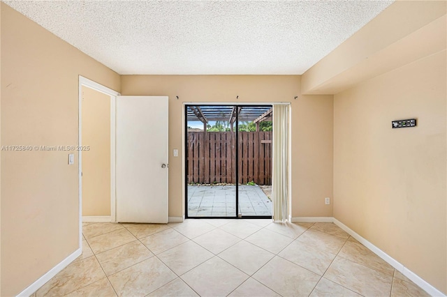 tiled empty room with a textured ceiling