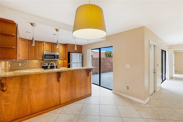 kitchen featuring light tile patterned floors, kitchen peninsula, stainless steel appliances, backsplash, and pendant lighting