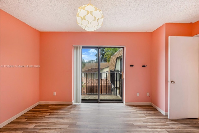 unfurnished room featuring a textured ceiling and light hardwood / wood-style flooring