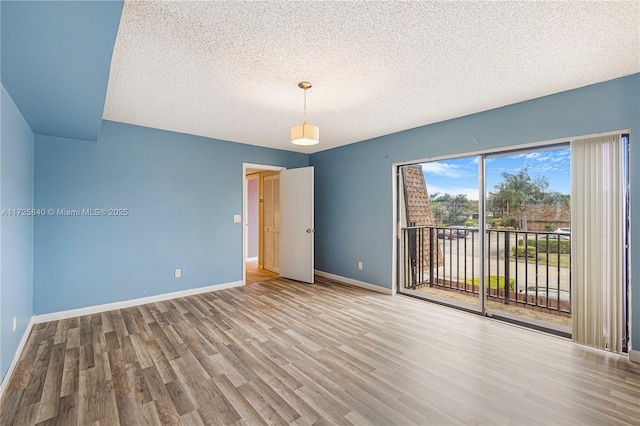 empty room featuring a textured ceiling and light wood-type flooring