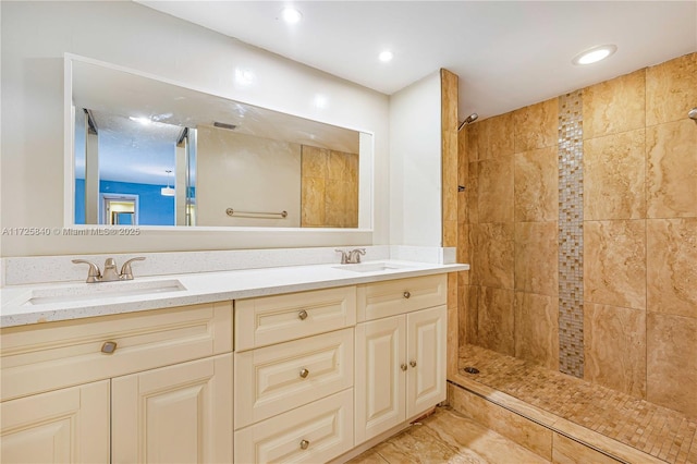 bathroom featuring tiled shower and vanity