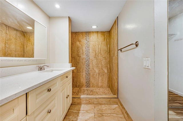 bathroom featuring vanity and tiled shower