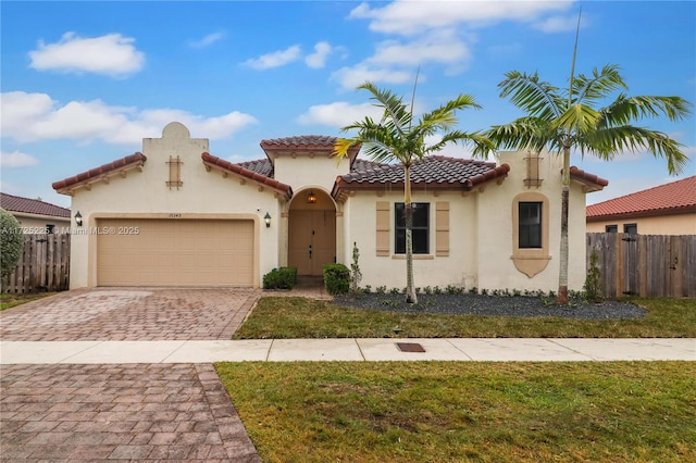 mediterranean / spanish home featuring a garage and a front yard