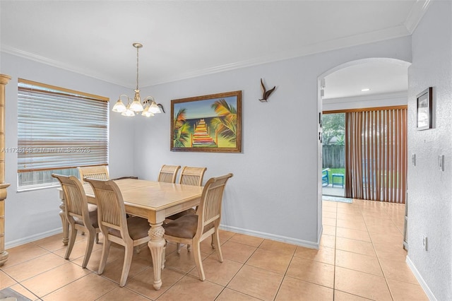 tiled dining space featuring ornamental molding and a chandelier