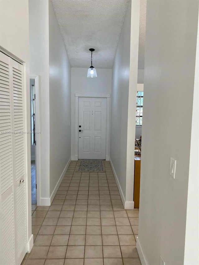 entryway featuring light tile patterned flooring and a textured ceiling