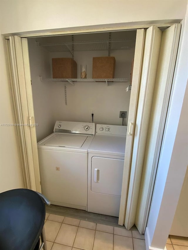 laundry room with washer and dryer and light tile patterned flooring