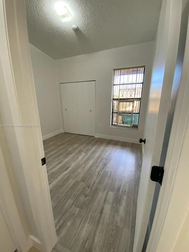 interior space with hardwood / wood-style flooring, a textured ceiling, and a closet