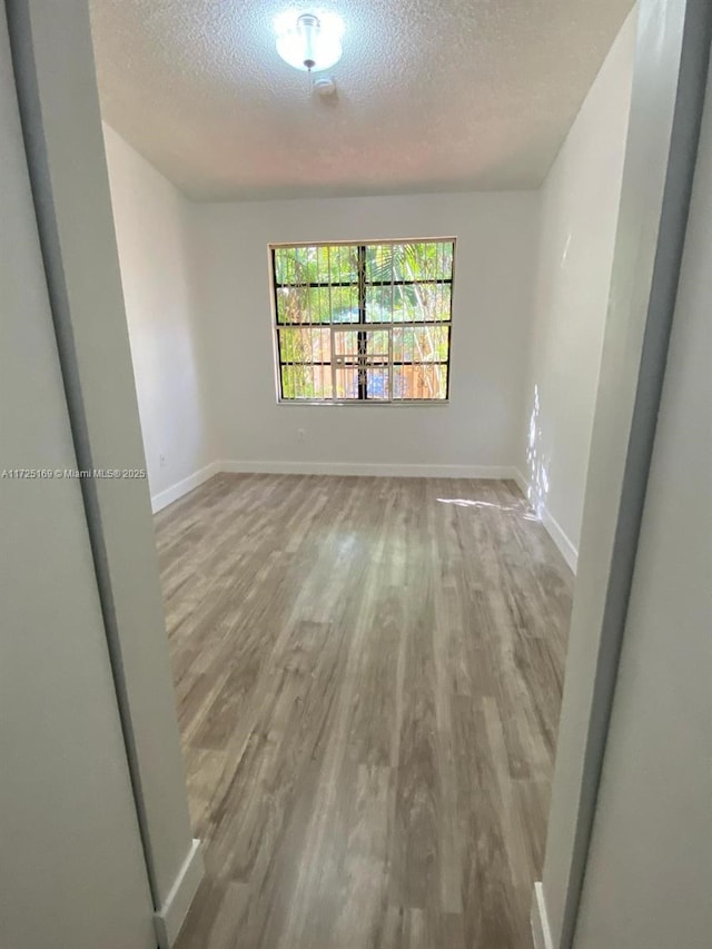 empty room with a textured ceiling and hardwood / wood-style floors