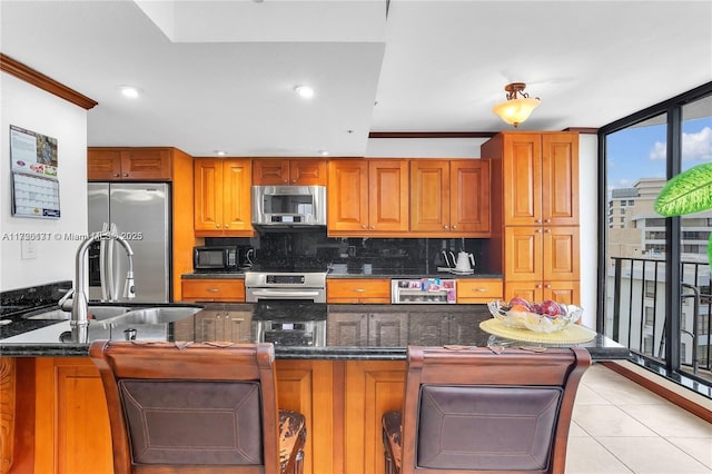 kitchen with floor to ceiling windows, stainless steel appliances, dark stone countertops, and backsplash