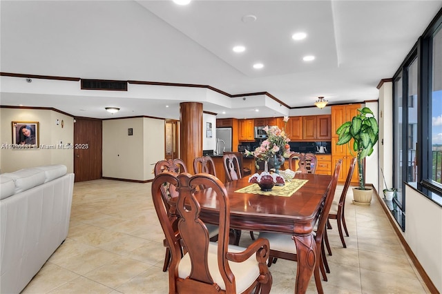 dining room featuring crown molding and light tile patterned floors