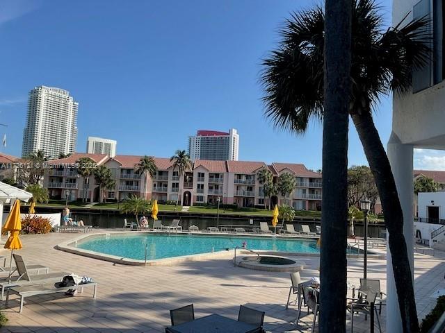 view of swimming pool featuring a hot tub and a patio area