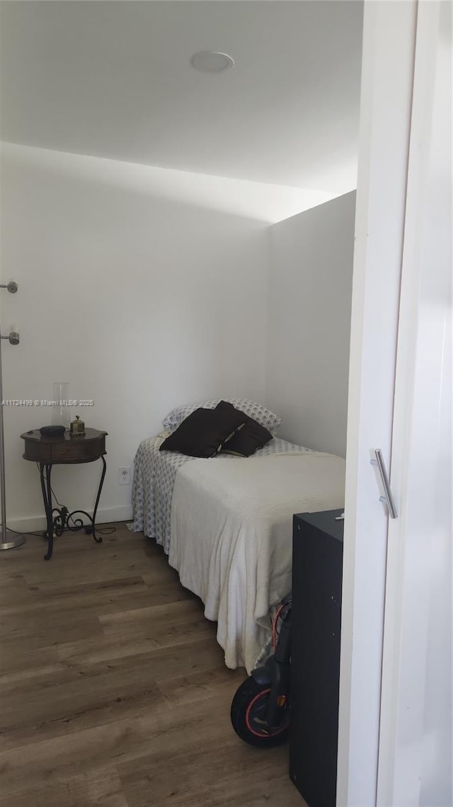 bedroom with dark wood-type flooring