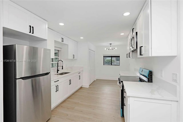 kitchen with stainless steel appliances, white cabinets, and sink