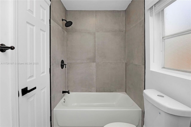 bathroom featuring toilet and tiled shower / bath combo