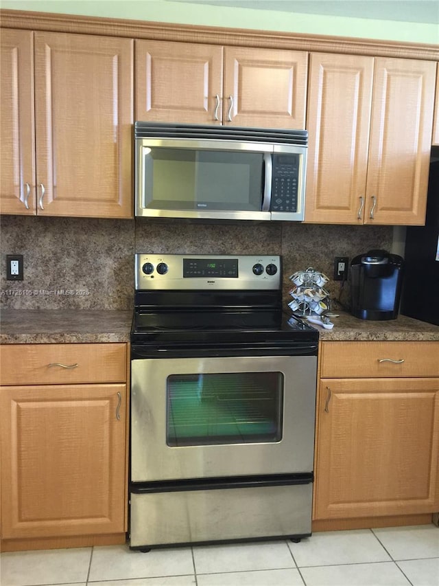 kitchen with decorative backsplash, light tile patterned floors, and appliances with stainless steel finishes