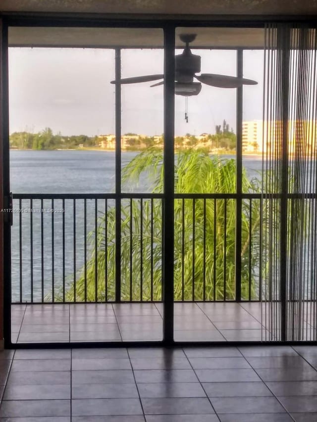 doorway to outside with ceiling fan and a water view