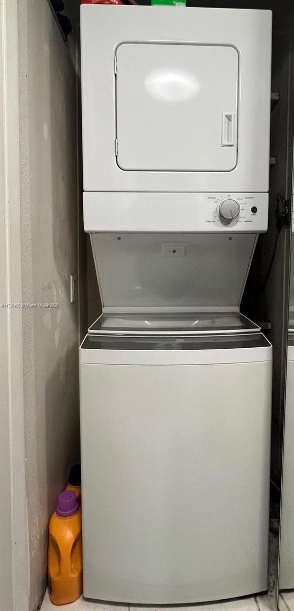 clothes washing area with stacked washer and clothes dryer