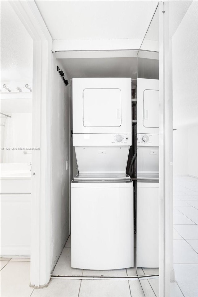 110 Lake Emerald Dr Unit 403, Oakland Park, FL 33309 - laundry room featuring light tile patterned flooring, stacked washer and clothes dryer, and laundry area