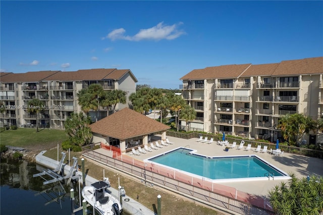 view of pool featuring a patio area, a boat dock, and a water view