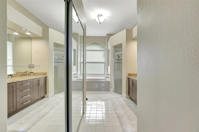 bathroom with independent shower and bath, tile patterned flooring, and vanity