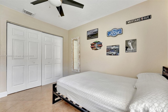 bedroom featuring light tile patterned flooring, a closet, and ceiling fan