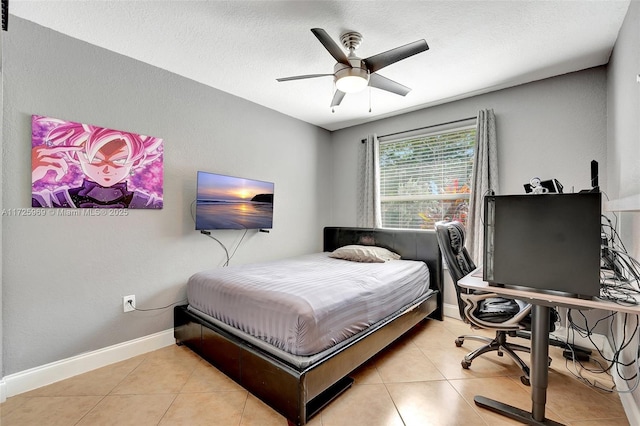 tiled bedroom featuring a textured ceiling and ceiling fan