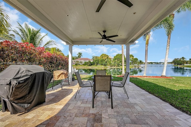 view of patio with ceiling fan, a water view, and grilling area