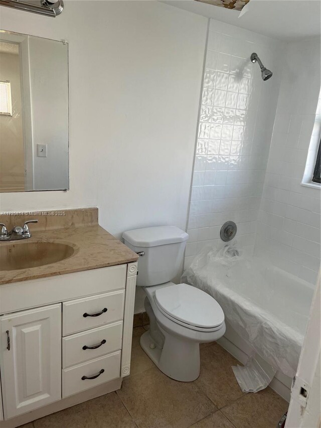 full bathroom featuring toilet, vanity, tile patterned flooring, and tiled shower / bath