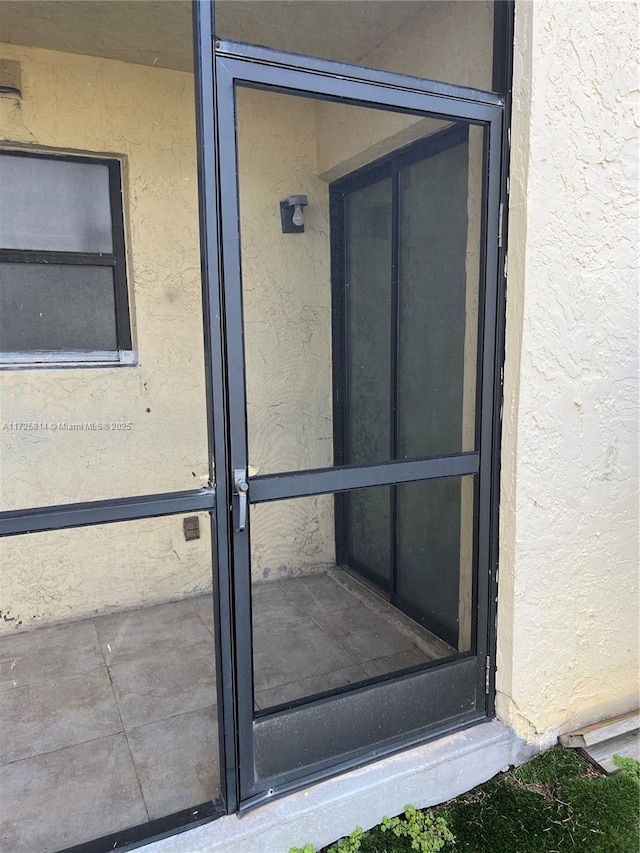 property entrance with stucco siding