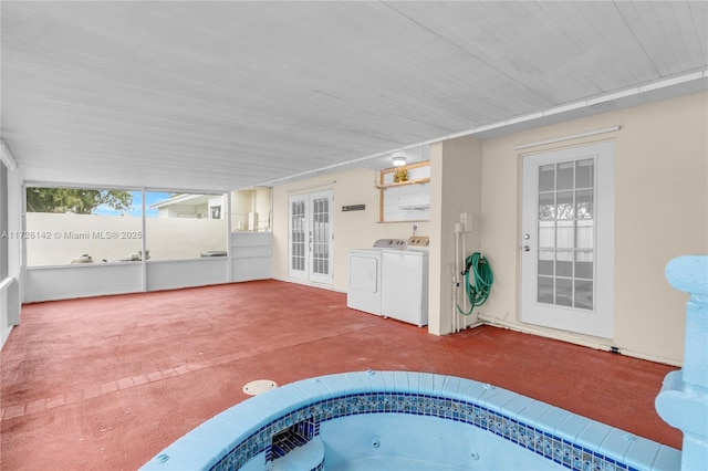 view of patio with independent washer and dryer, french doors, and a hot tub