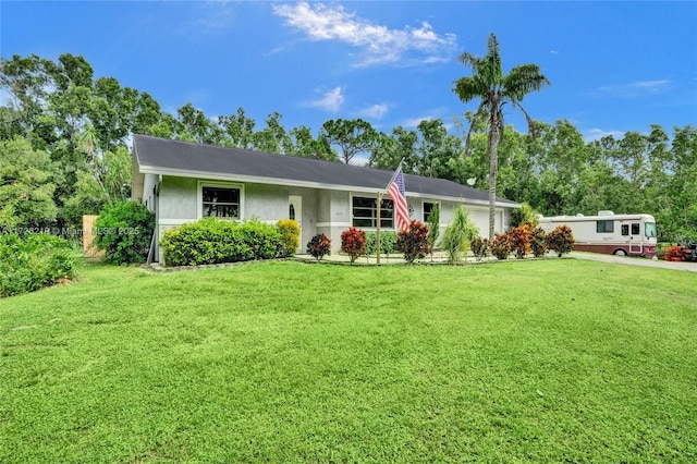 ranch-style house featuring a garage and a front lawn