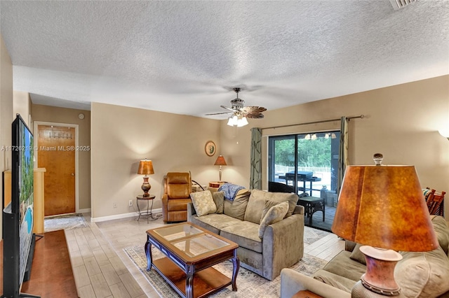 living room featuring a textured ceiling and ceiling fan