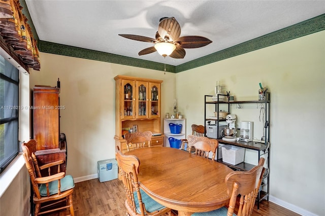 dining space with a textured ceiling, ceiling fan, and wood-type flooring