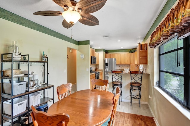 dining space with ceiling fan and light hardwood / wood-style floors