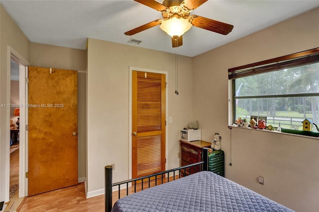 bedroom with a closet, ceiling fan, and light wood-type flooring