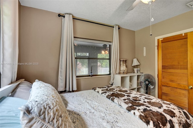 bedroom featuring a textured ceiling and ceiling fan