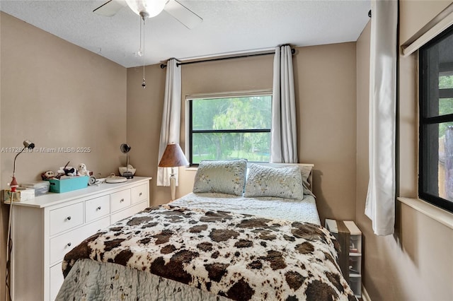 bedroom with a textured ceiling and ceiling fan