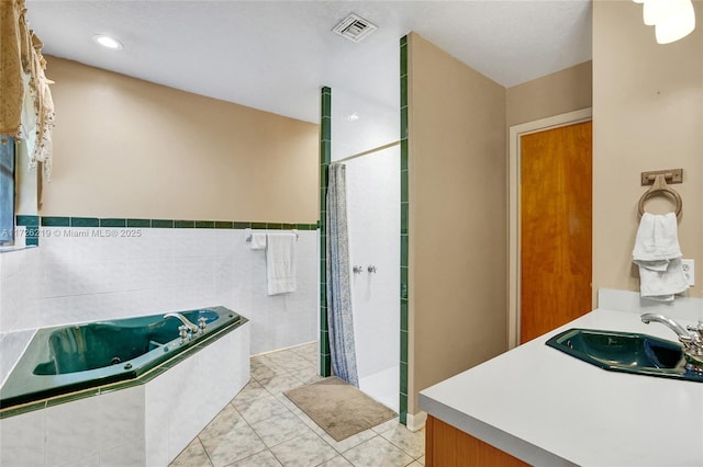 bathroom with tile walls, tile patterned flooring, independent shower and bath, and vanity