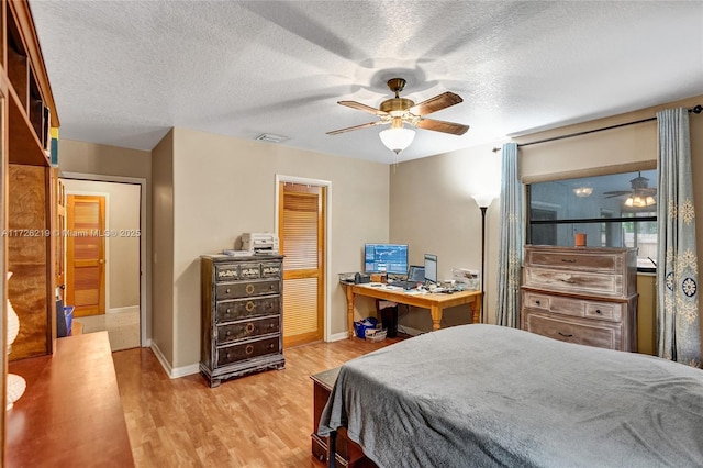 bedroom with a textured ceiling, ceiling fan, light hardwood / wood-style flooring, and a closet