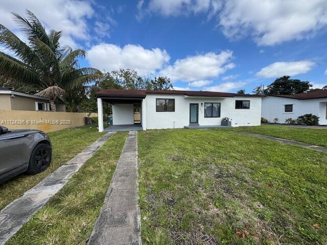 ranch-style home with a carport and a front lawn