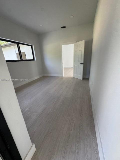 unfurnished room with wood-type flooring