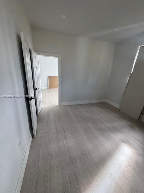 unfurnished room with hardwood / wood-style flooring